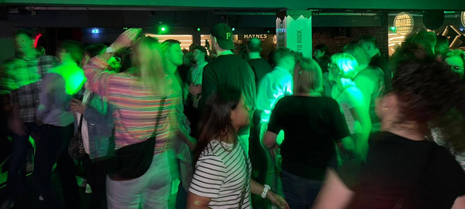 Menschen tanzen auf einer Tanzfläche eines Münsterschen Clubs.