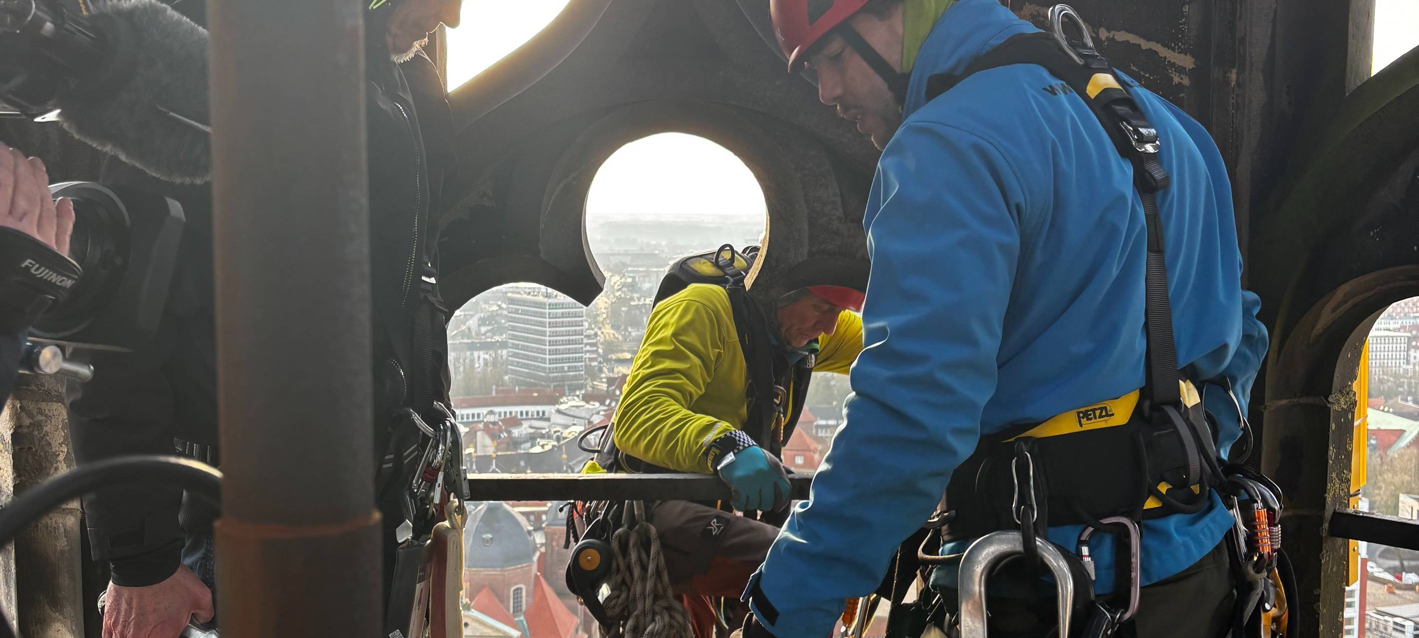 Drei Männer in einem Kirchturm.